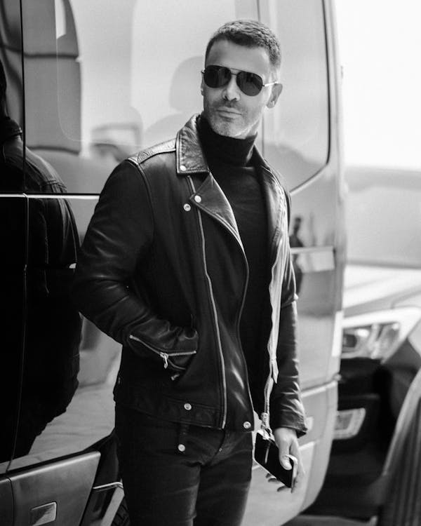 Grayscale Photo of a Man Wearing Black Leather Jacket 