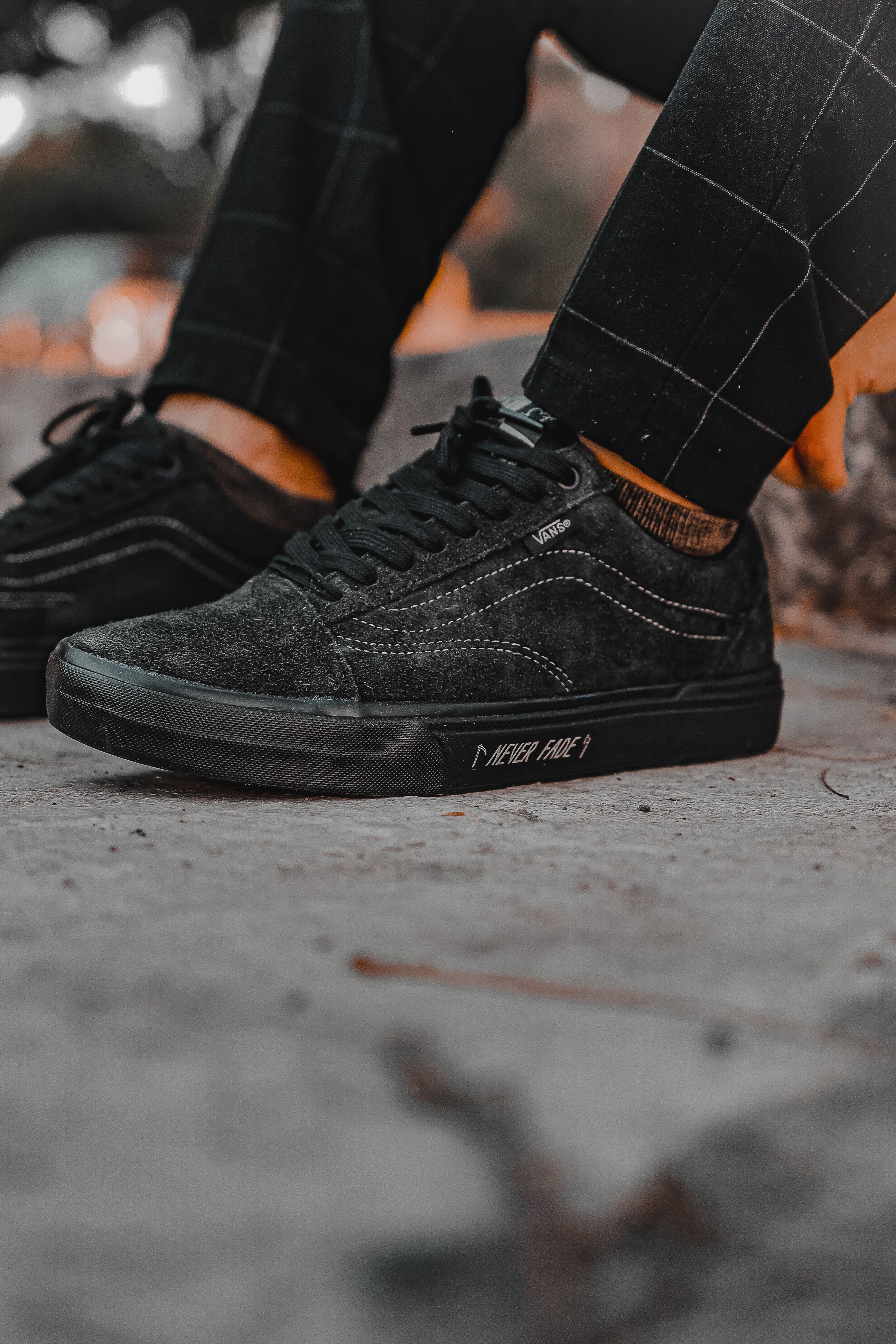 Black sneaker and cargo pant detail shot on concrete floor