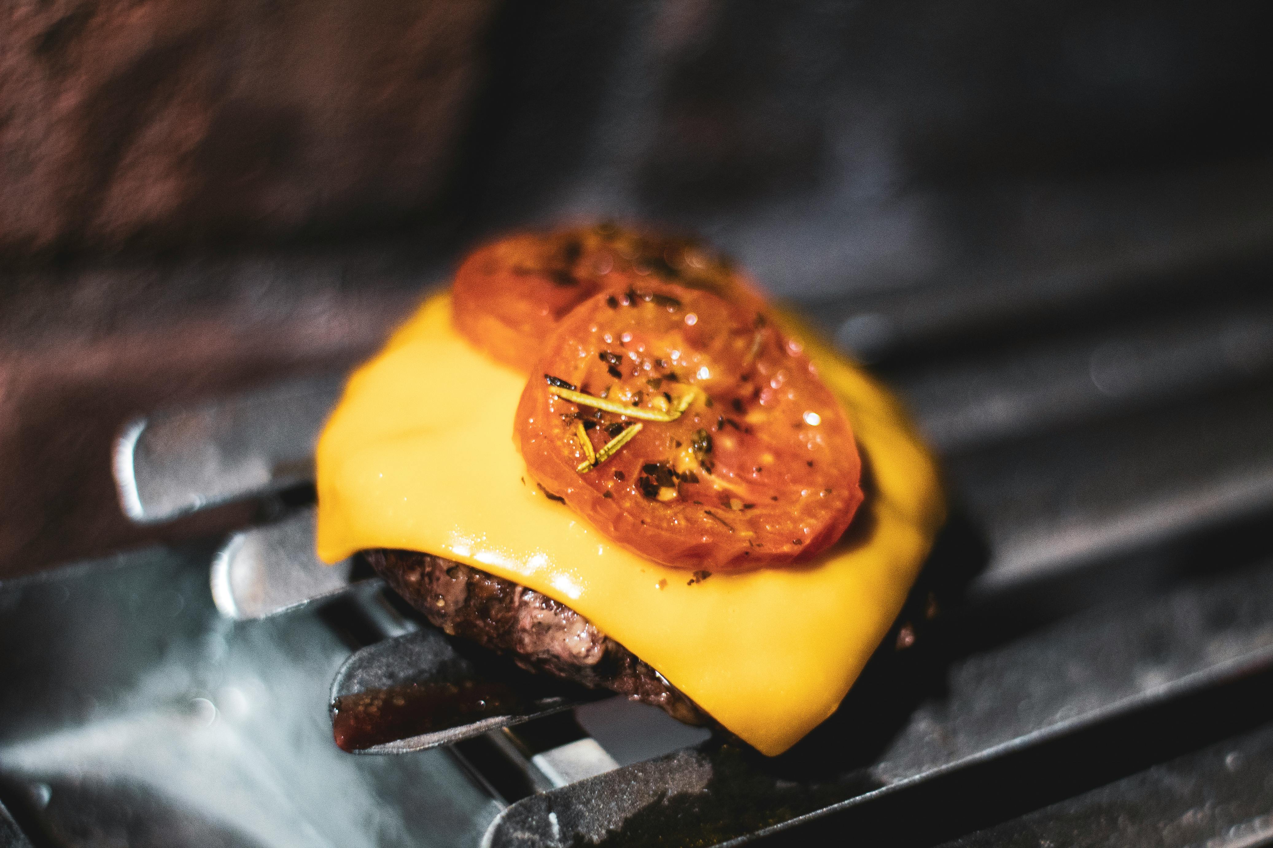 Sliced Tomato on Cheeseburger on a Griller · Free Stock Photo