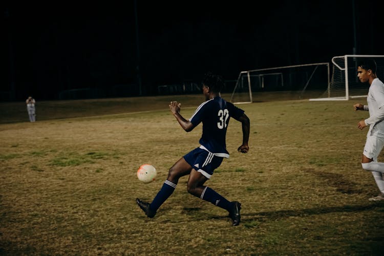 Men Playing Football At Night