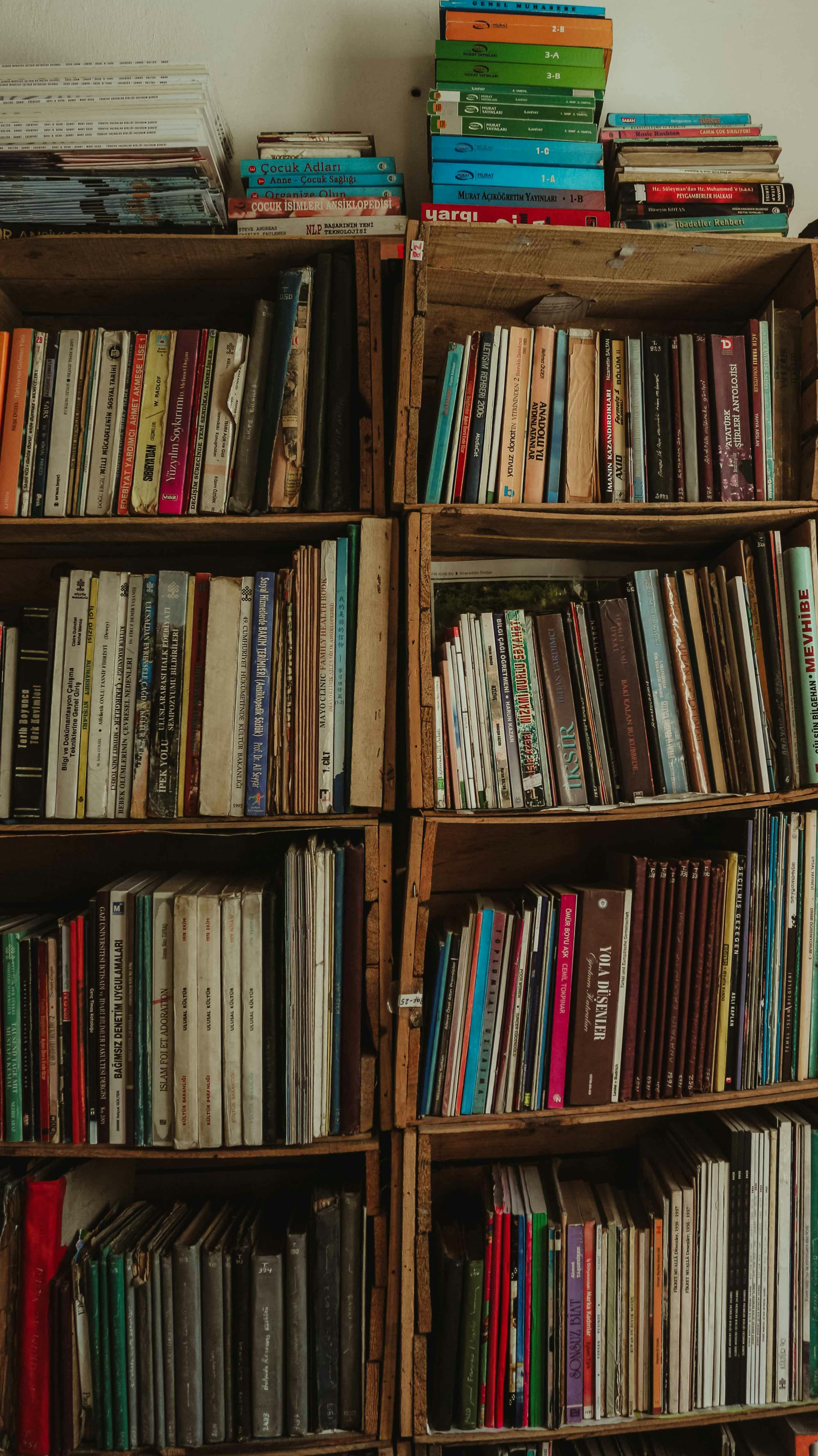 A vertical stack of vintage bookshelves filled with colorful, assorted books.