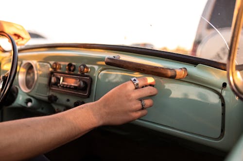 Free man reaching for glove box in VW Bug Stock Photo
