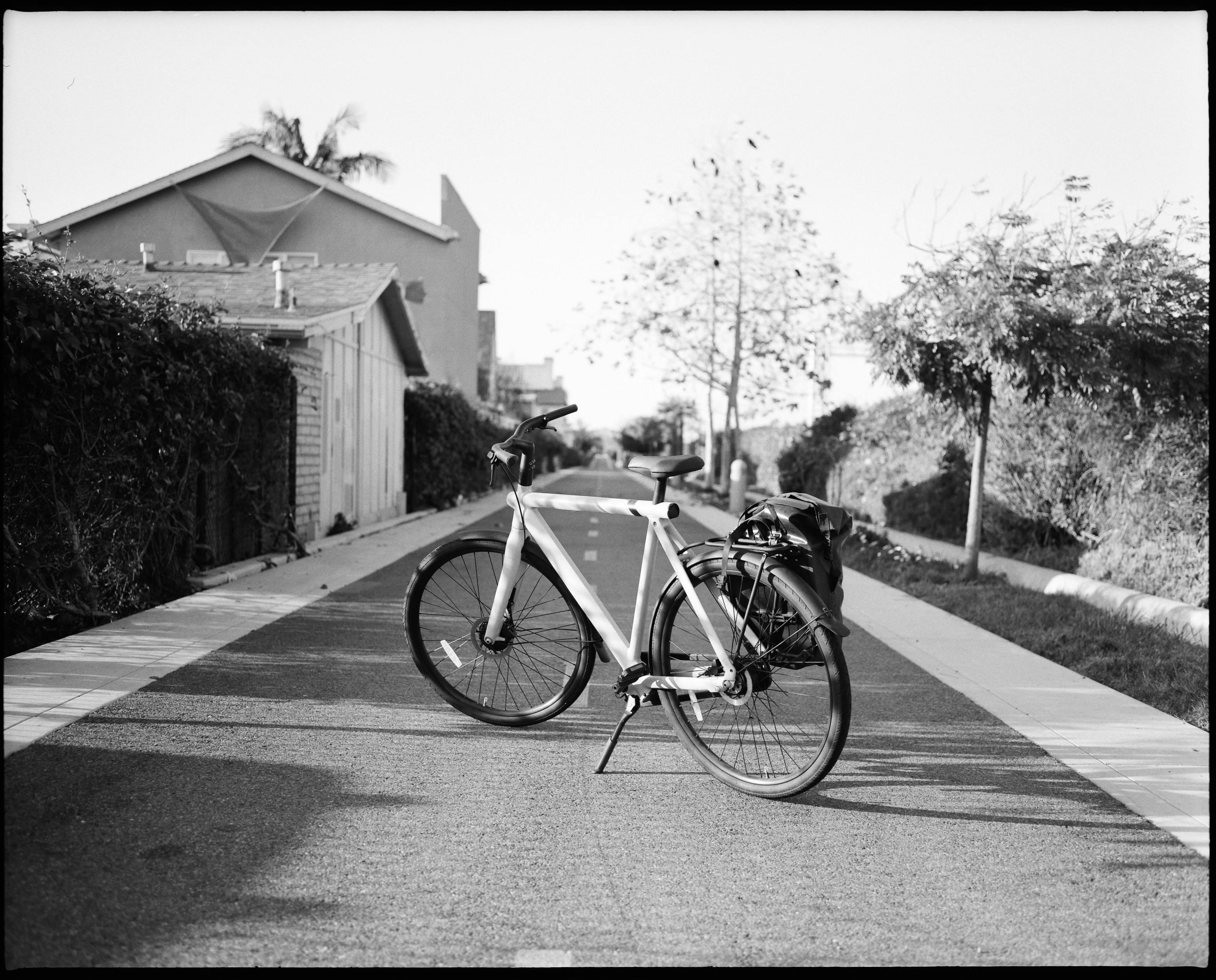 A black and white photo of a bicycle parked on a peaceful, sunny street in Oceanside, California.