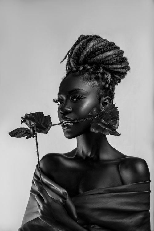 Free Artistic black and white portrait of a woman holding roses, evoking elegance and glamour. Stock Photo