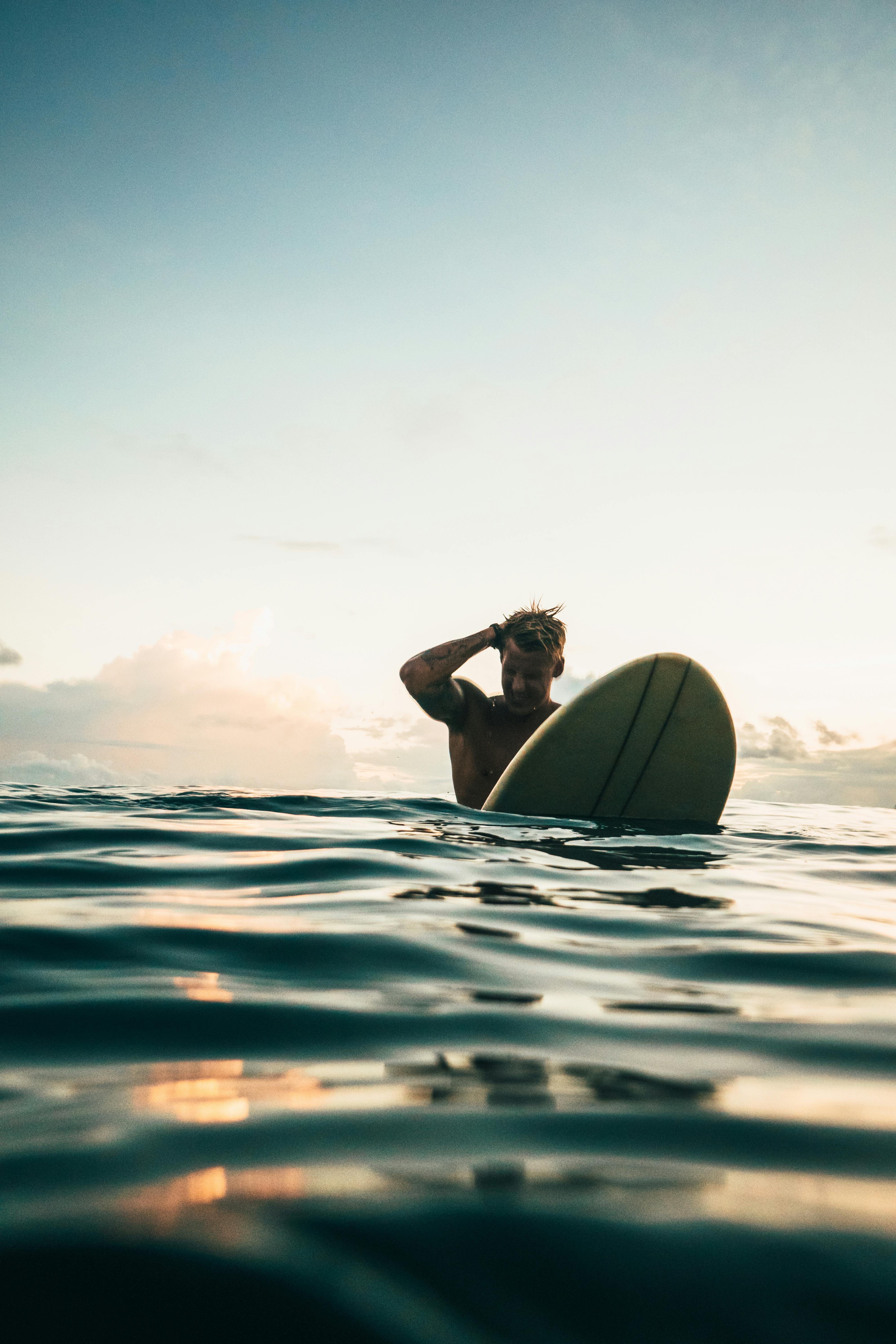 man holding white surfboard