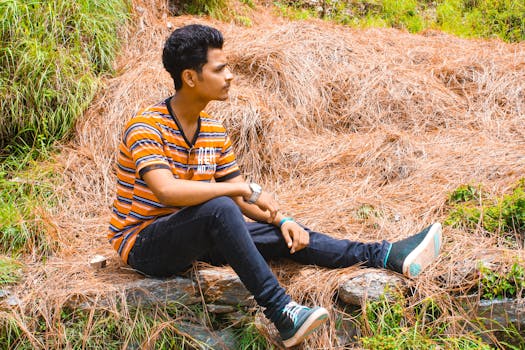 Man Wearing Blue Jeans Sitting on Brown Hay