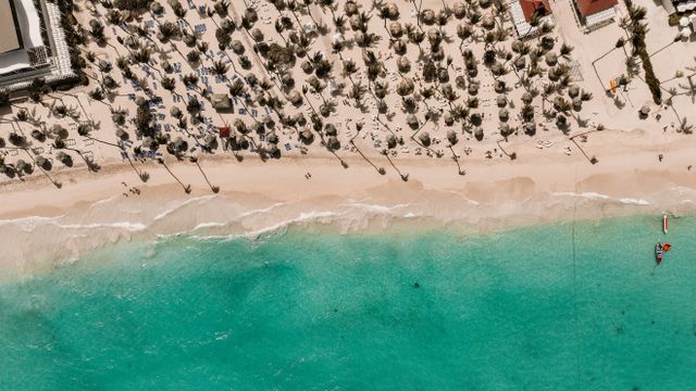 Stunning aerial view of a tropical beach in the Dominican Republic with white sand and turquoise water.