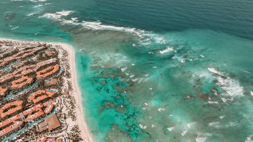 Free A breathtaking aerial view of a tropical beach with turquoise waters and resort rooftops. Stock Photo