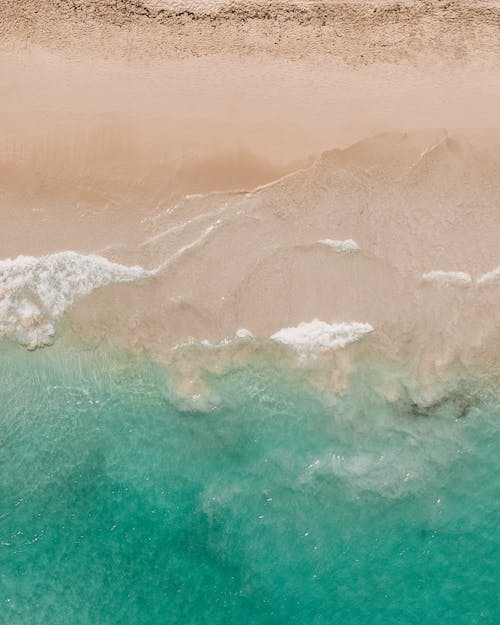 Aerial View of Ocean Waves on White Sand Beach