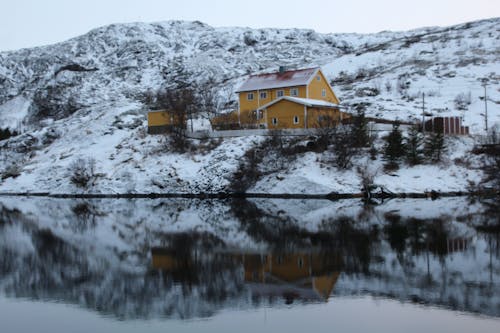 House on Hill in Snow near Water