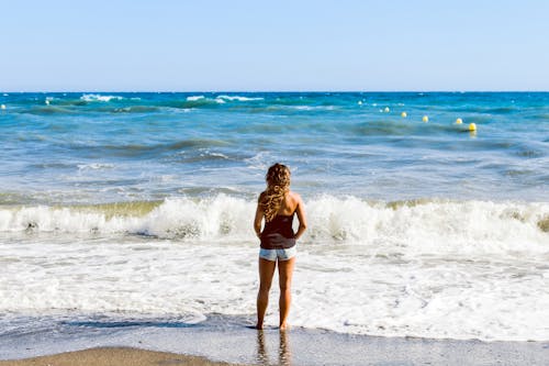 Ücretsiz Deniz Kıyısı üzerinde Duran Kadın Fotoğrafı Stok Fotoğraflar