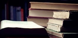 昏暗的图书馆里，一堆老式精装书象征着知识与智慧