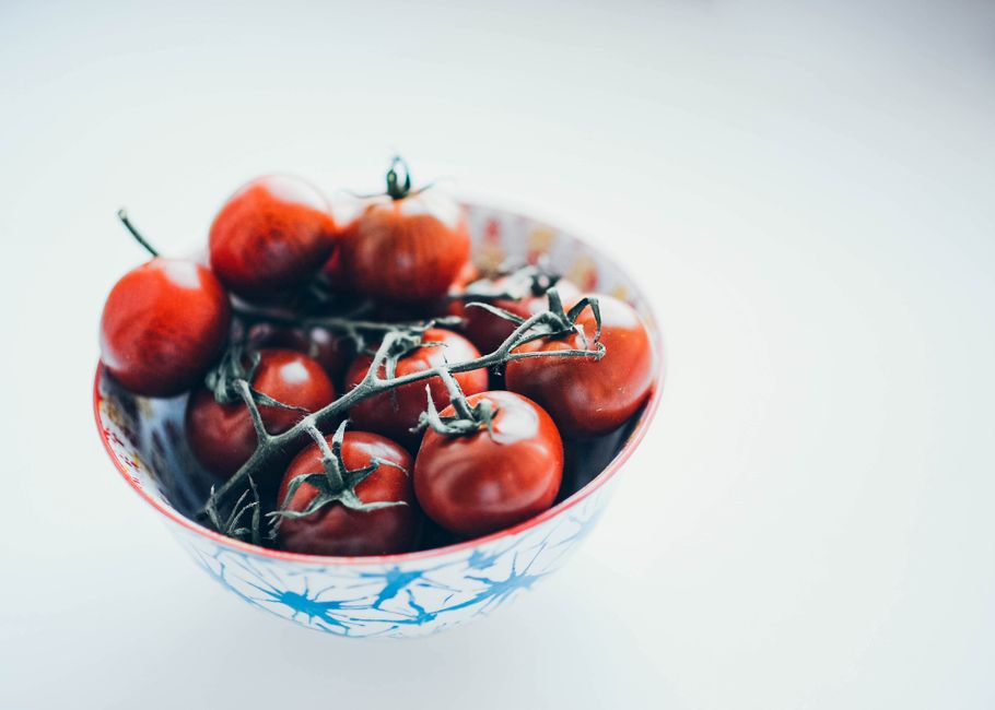 Bright red cherry tomatoes in a decorative bowl, perfect for healthy meals and kitchen decor.
