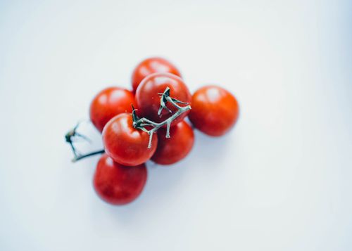 Free Vibrant cherry tomatoes on a white background, showcasing freshness and simplicity. Stock Photo