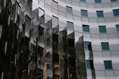 Free A striking modern building with a rounded glass facade reflecting urban design. Stock Photo