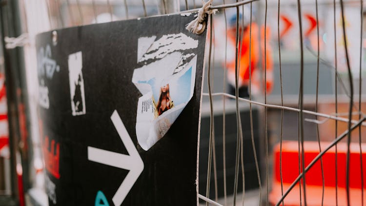 Board With Stickers On Net Fence