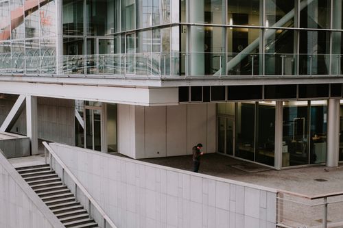 Free Contemporary city architecture with a lone man standing near stairs. Modern urban scene. Stock Photo
