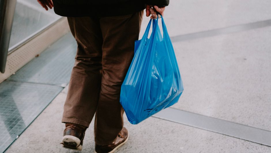 person carrying grocery bags parking lot