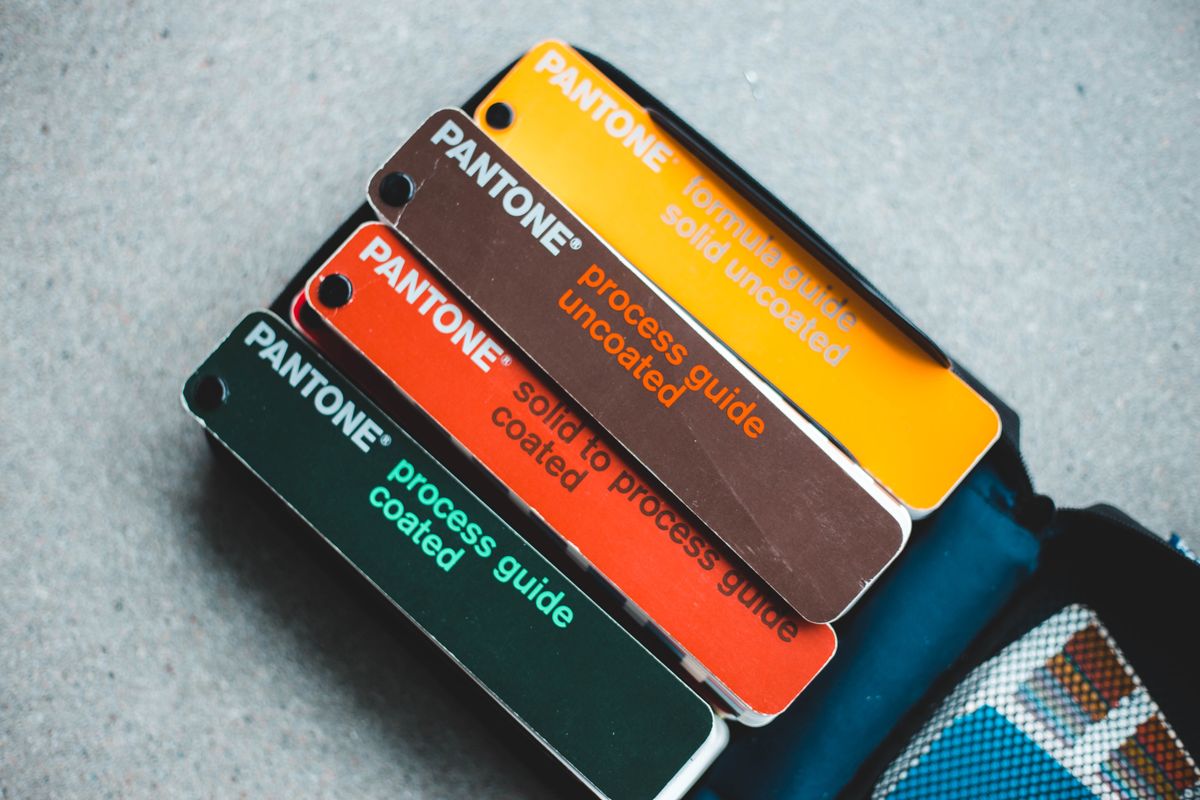 Pantone coated and uncoated colour guides fanned open on a grey surface