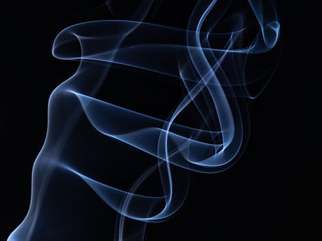 Beautiful abstract blue smoke swirls elegantly against a black background, creating a mesmerizing visual effect.