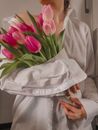 Woman in White Robe Holding Pink Tulips