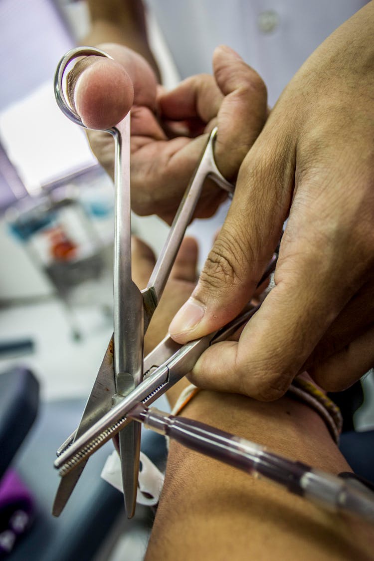 A Person Holding A Scissor