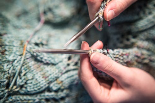 Close-Up Photo of a Person's Hands Knitting