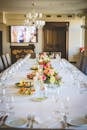 长餐桌优雅地摆放着花卉中心和餐具，准备着一顿正式的餐宴