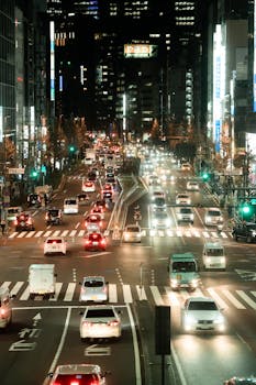 Vibrant nightlife in Tokyo with bustling traffic and illuminated streets captured at night.