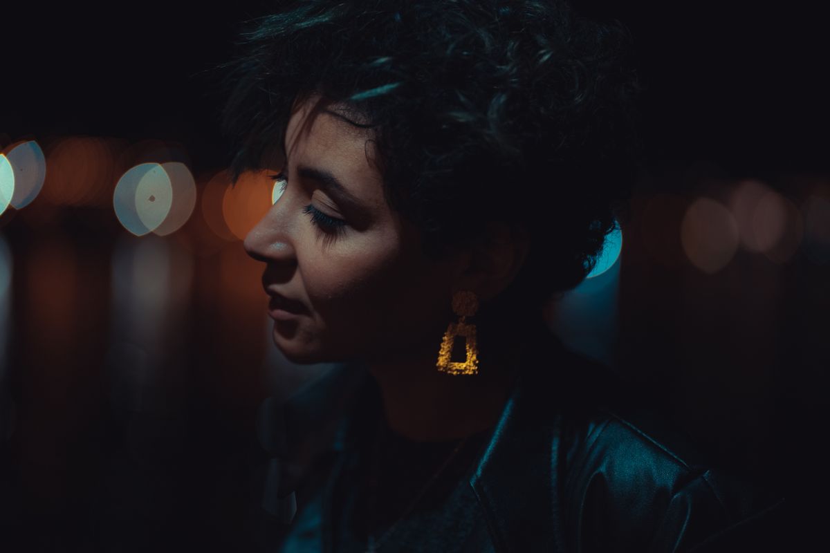 Side profile of a woman with short hair and striking earrings, captured in bokeh lighting , by vii wolves on Pexels