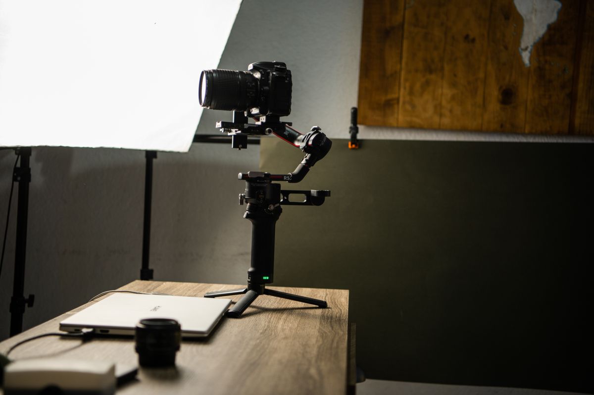 Aparat foto montat pe gimbal intr-un studio cu softbox si laptop