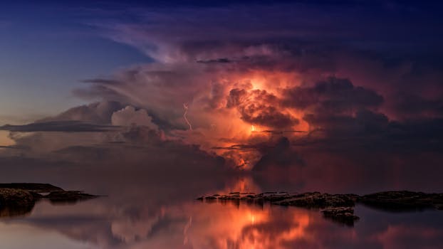一幅惊人的日落景象描绘了暴风雨中的海景，生动的闪电倒映在平静的水面上