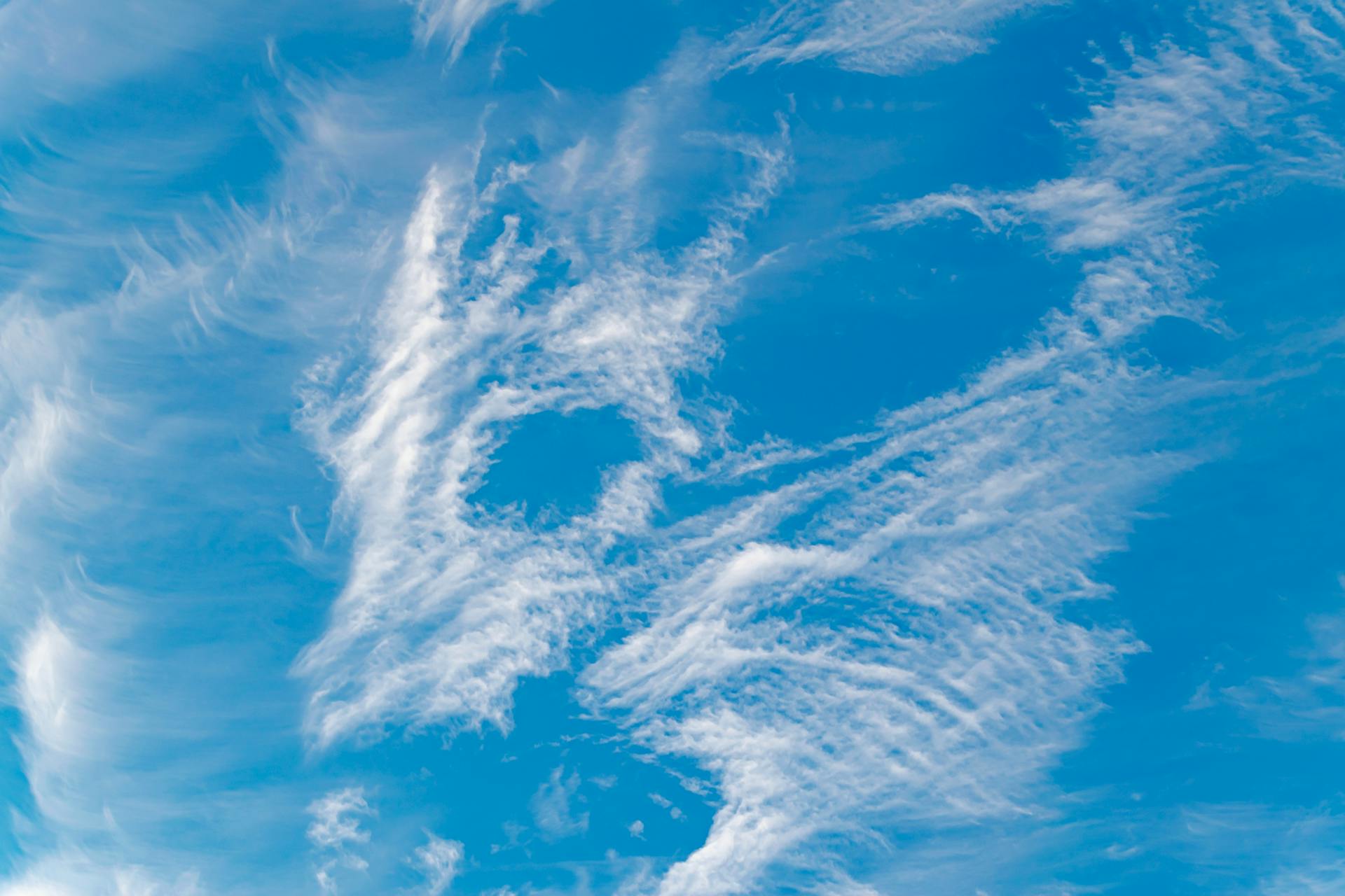 A vivid depiction of cirrus clouds against a bright blue sky, capturing natural beauty.