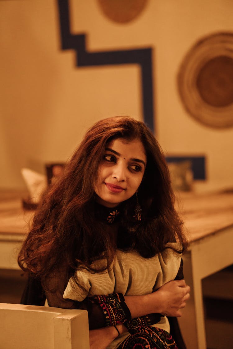 Woman In Traditional Clothes Sitting On Chair