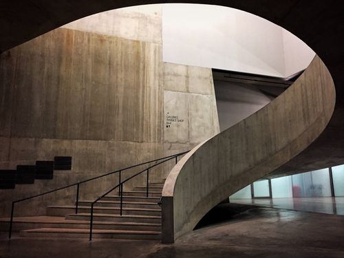 Free Curved concrete staircase with metal railings in London, showcasing minimalist architecture. Stock Photo