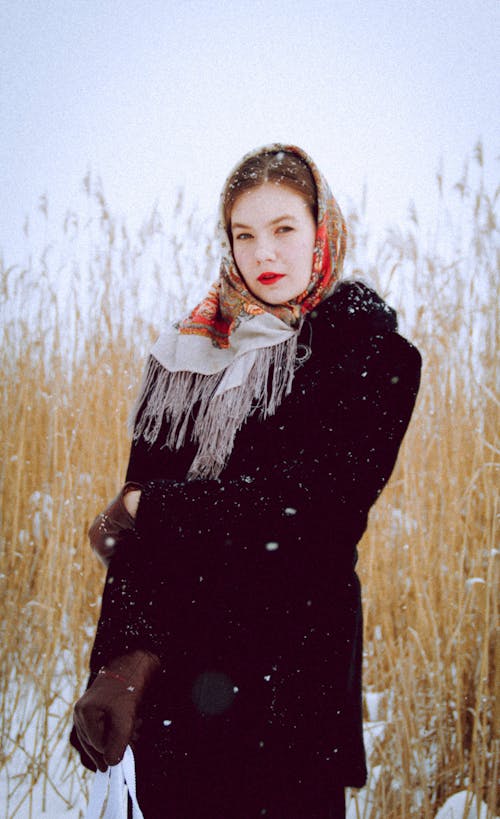 
A Woman Wearing a Black Jacket and a Scarf during Winter