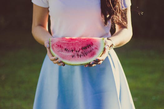 Woman in White and Blue Dress Holding Water Melon