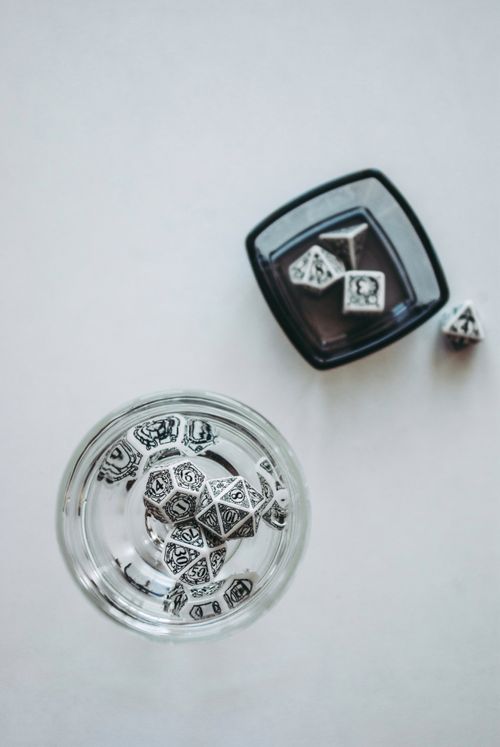 Free Ornate dice in clear bowls on a white background, showcasing elegant design. Stock Photo