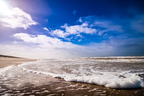 бесплатная Велосипедные волны на море под облачным голубым небом в дневное время Стоковое фото