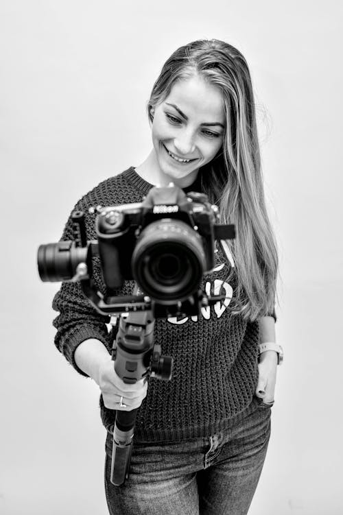 
A Grayscale of a Woman Holding a Camera