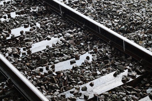 潮湿的铁轨上散落着砾石，雨滴敲打着钢轨