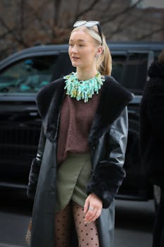 Fashionable woman wearing a statement necklace and leather coat on a New York street.