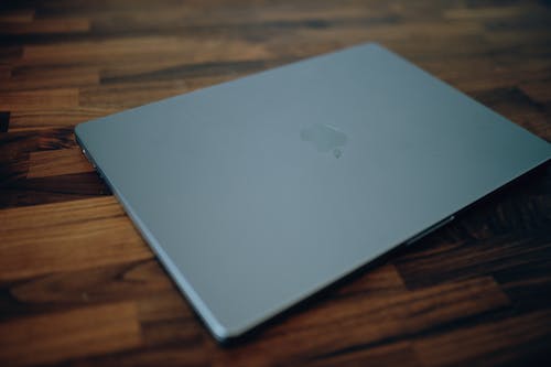 Free Silver Macbook on Brown Wooden Table Stock Photo