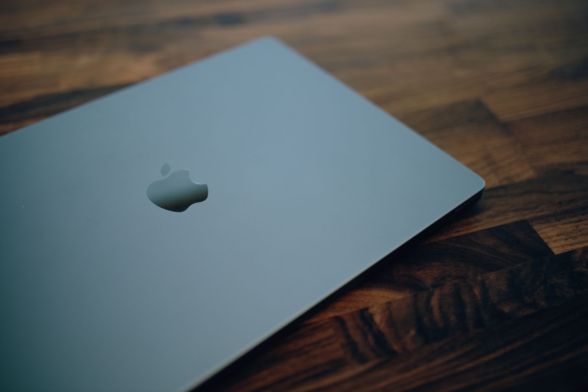 Close-up of a sleek modern laptop with minimalistic design on a wooden table surface.