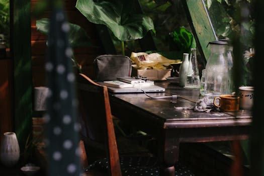 室内工作空间宁静宜人，配有笔记本电脑和咖啡，窗外绿树成荫，非常适合创意工作