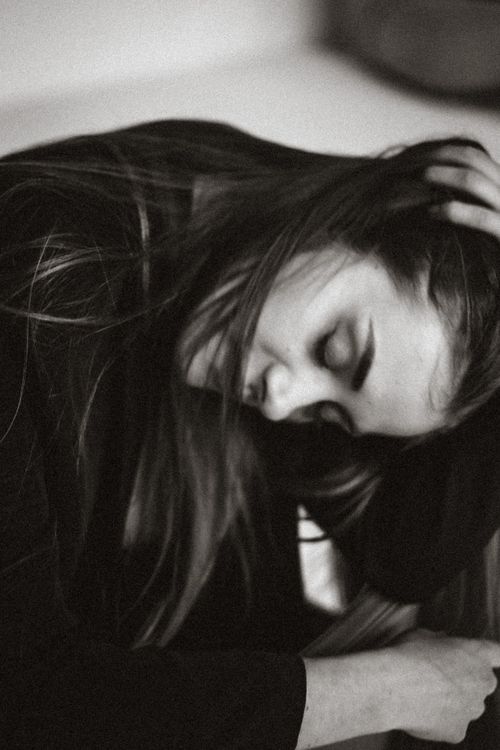 Free Serene black and white portrait of a woman with long hair resting against her hand. Stock Photo