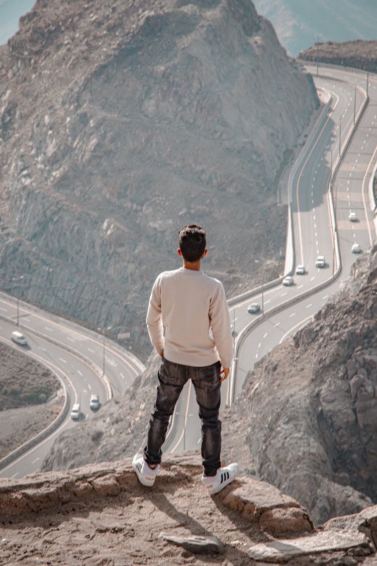 Man Standing On A Cliff Overlooking The Roads