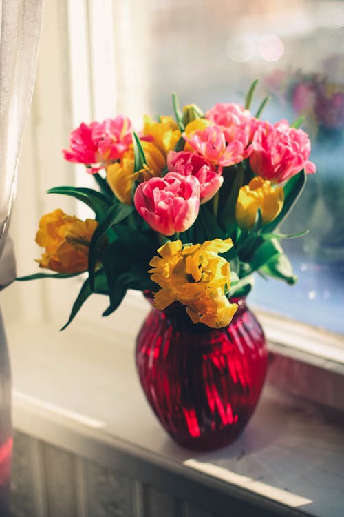 Flor De Pétalos De Rosa Y Amarillo En Jarrón De Cristal Rojo