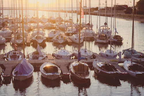 Planche De Bois Brun à Côté De Bateaux à Voile Dans Un Plan D'eau Pendant La Journée