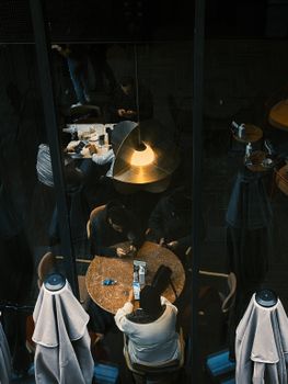 High-angle view of people socializing in a cozy cafe setting with artistic lighting.